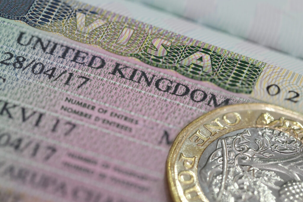 United Kingdom Visa in the passport with one pound coin